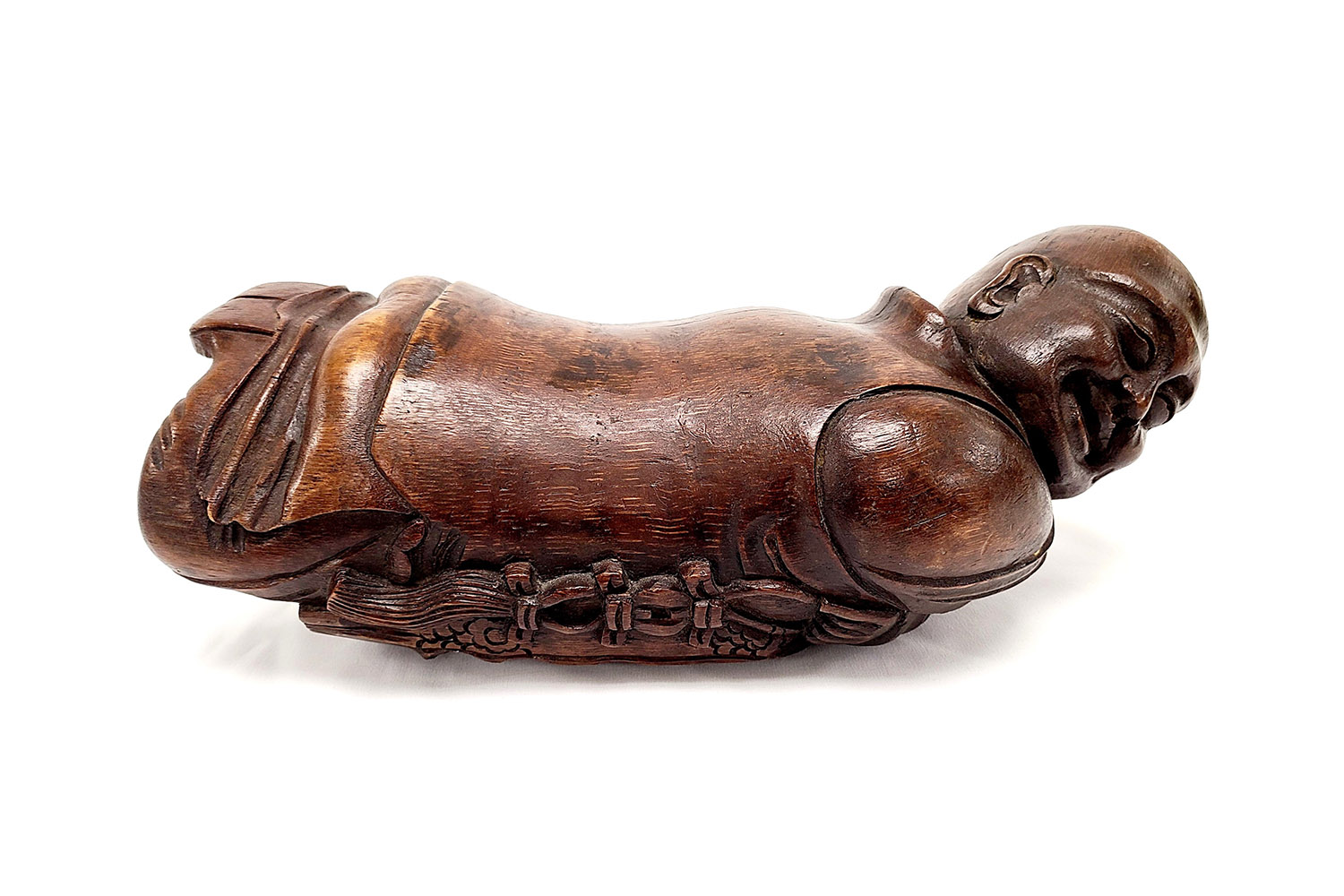 wooden headrest in the shape of a man lying down