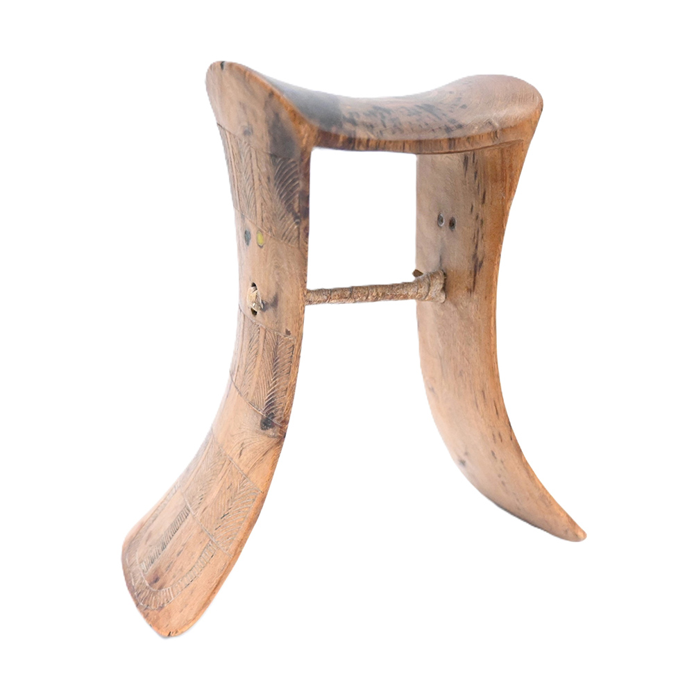 wooden headrest with concave sides and geometric carving