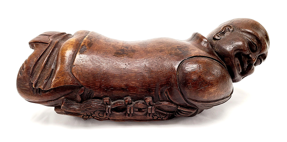 Wood headrest shaped like a sleeping monk